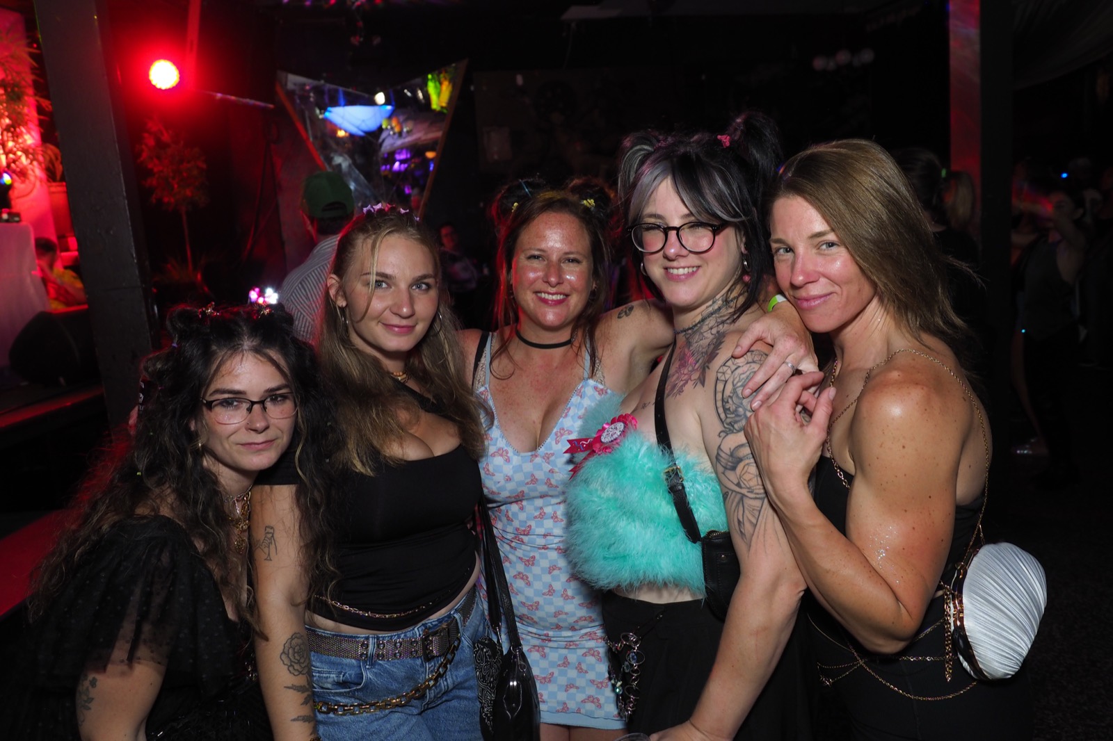 Five friends posing together on the dance floor at a Bump & Grind night