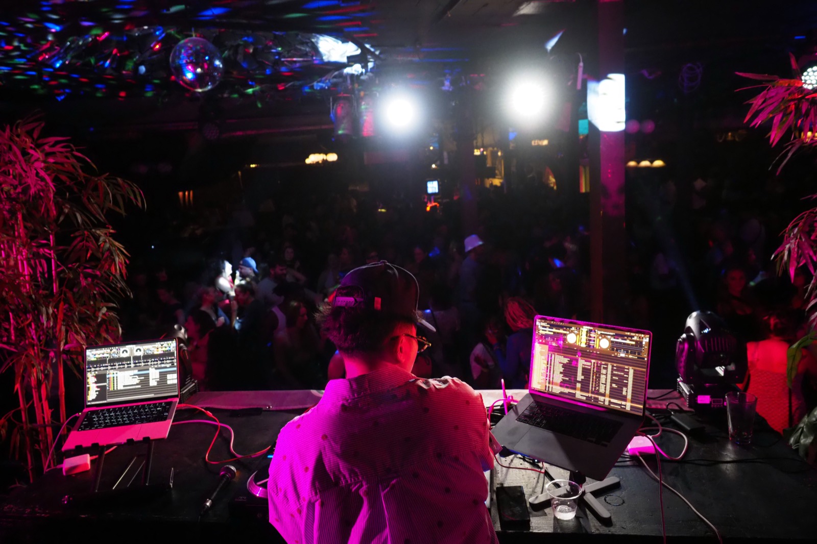 The DJ looking out over a packed dance floor from behind the decks