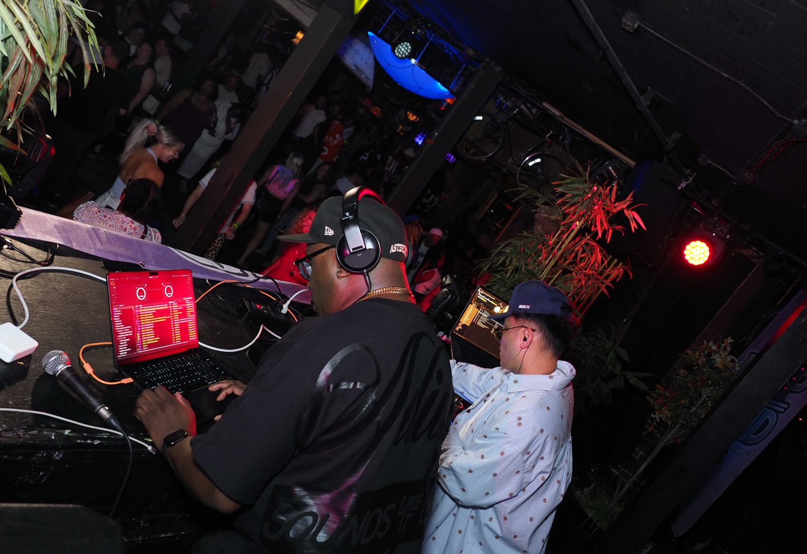 Two DJs working the booth above the crowd